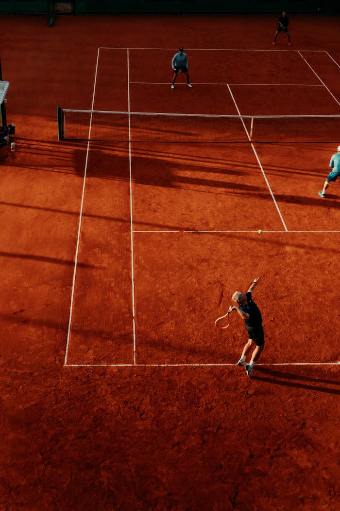 Crafting Captivating Headlines: Your awesome post title goes here Overhead view of a tennis match on a clay court with four players competing in doubles.